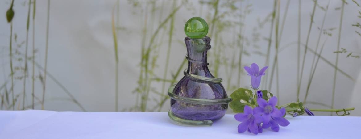 Siddy Langley Spiral scent bottle in purple with a green stopper and green trail snaking around the piece